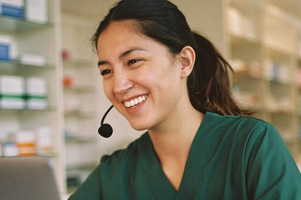 A smiling member of the EverydayMeds clinical team wearing a headset