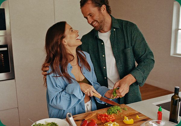 A couple laughing while preparing a healthy meal together